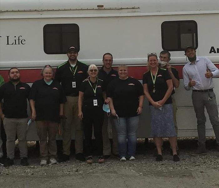 Crew standing in front of a Red Cross Bus